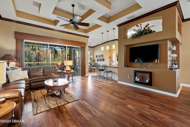 living room featuring hardwood / wood-style floors, crown molding, ceiling fan, and coffered ceiling