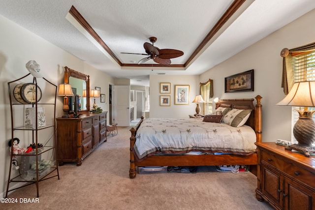 bedroom featuring a textured ceiling, ceiling fan, a raised ceiling, and light carpet