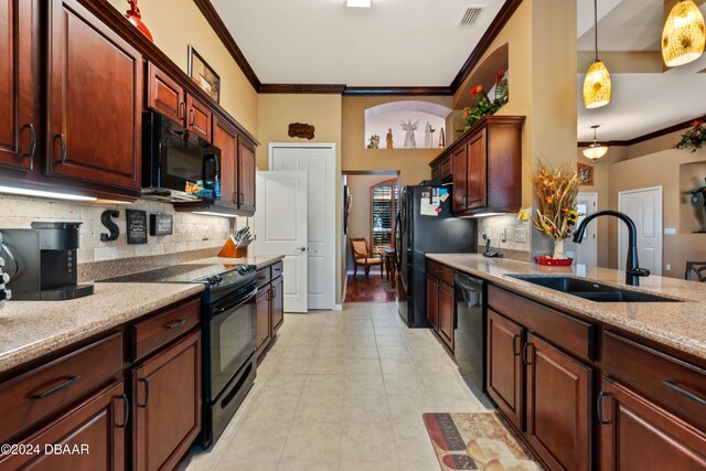 kitchen featuring sink, hanging light fixtures, light stone counters, crown molding, and black appliances