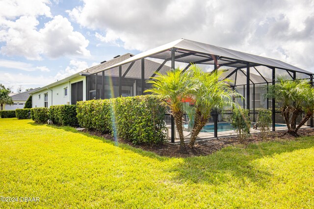 exterior space featuring a lanai and a lawn