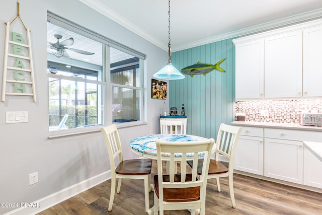 dining area with ceiling fan, ornamental molding, and light hardwood / wood-style flooring