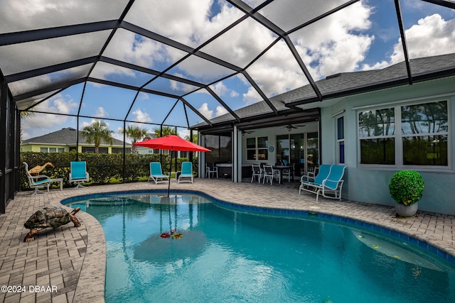 view of pool featuring ceiling fan, a patio area, and glass enclosure