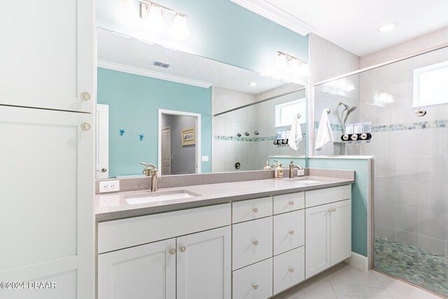 bathroom with ornamental molding, vanity, and a tile shower