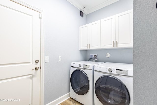 laundry room with cabinets, washing machine and clothes dryer, crown molding, and light hardwood / wood-style flooring