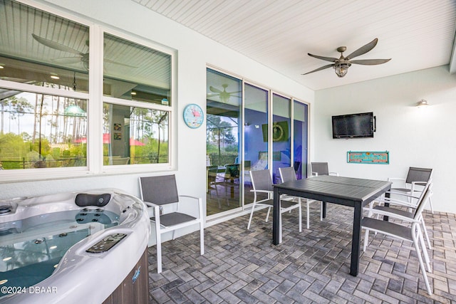 sunroom with a hot tub and ceiling fan