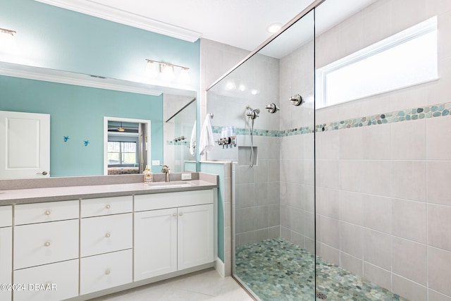 bathroom featuring ornamental molding, tiled shower, vanity, and tile patterned floors