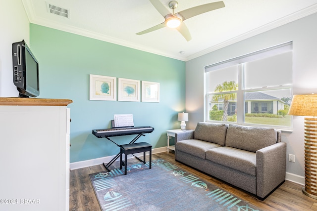 living room with crown molding, wood-type flooring, and ceiling fan