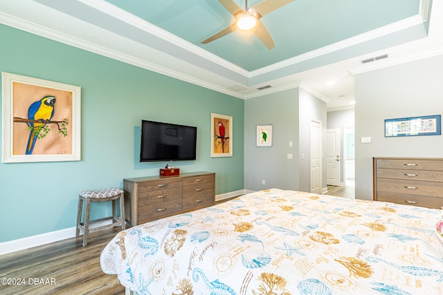 bedroom featuring crown molding, ceiling fan, a tray ceiling, and hardwood / wood-style floors