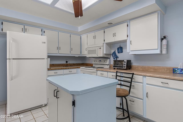 129 Sand Fiddler Ct, Daytona Beach, FL 32119 - kitchen featuring white appliances, light tile patterned floors, a kitchen island, light countertops, and white cabinetry