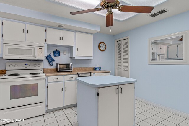 129 Sand Fiddler Ct, Daytona Beach, FL 32119 - kitchen featuring white appliances, light countertops, light tile patterned flooring, and white cabinetry