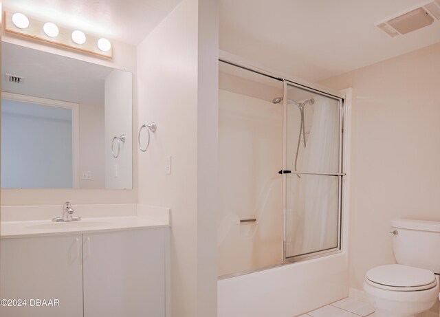 full bathroom featuring enclosed tub / shower combo, tile patterned floors, toilet, and vanity