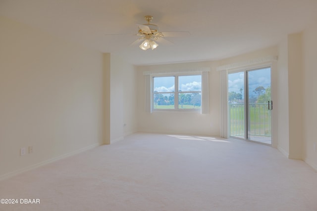 carpeted spare room with ceiling fan