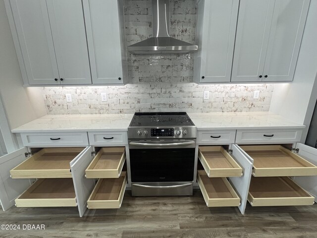 9 Evanston Ln, Palm Coast, FL 32164 - kitchen featuring stainless steel range with electric stovetop, wall chimney range hood, decorative backsplash, dark wood-type flooring, and light stone counters
