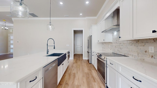 kitchen with decorative light fixtures, stainless steel appliances, white cabinetry, light stone countertops, and wall chimney exhaust hood