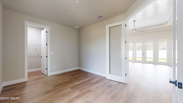 spare room with light wood-style flooring, visible vents, and baseboards