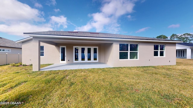 back of house with stucco siding, fence, a patio, and a yard