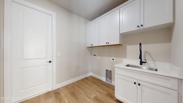 laundry room with cabinet space, baseboards, hookup for a washing machine, hookup for an electric dryer, and a sink