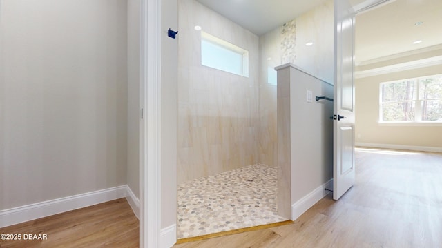 full bathroom with plenty of natural light, a walk in shower, and wood finished floors