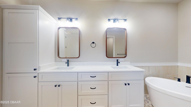 bathroom featuring double vanity, a wainscoted wall, and a sink