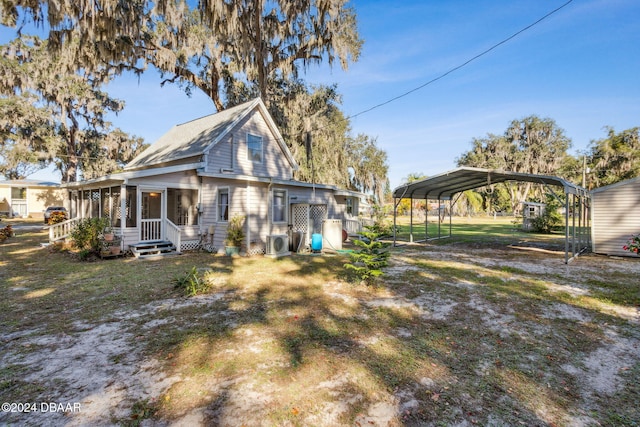 rear view of property featuring a carport, a sunroom, and a lawn