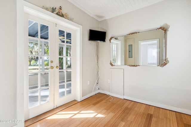 unfurnished room featuring wood-type flooring, a wealth of natural light, and french doors