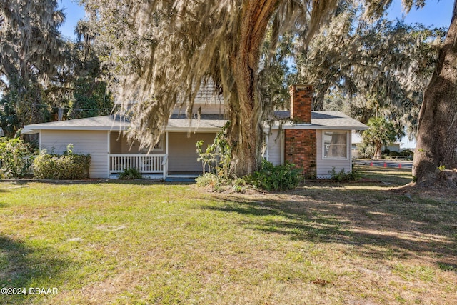 back of house with a porch and a yard