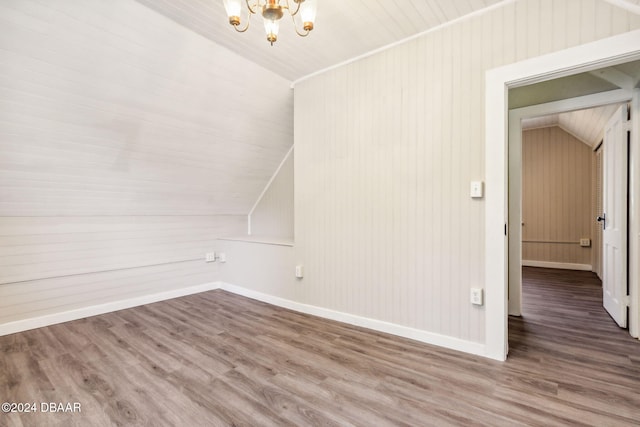 bonus room featuring an inviting chandelier, vaulted ceiling, and hardwood / wood-style flooring