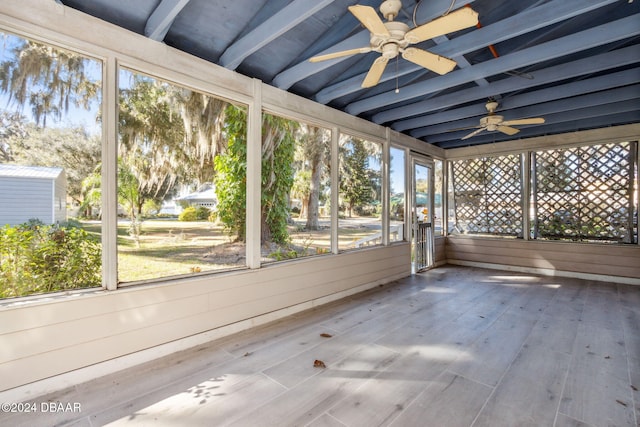 unfurnished sunroom featuring vaulted ceiling with beams and ceiling fan