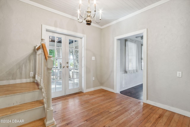 entryway featuring french doors, hardwood / wood-style flooring, an inviting chandelier, and crown molding