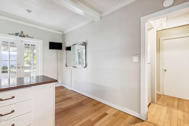 interior space with white cabinets, beam ceiling, french doors, and light hardwood / wood-style flooring