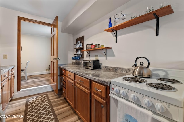 kitchen with white electric range and light hardwood / wood-style floors