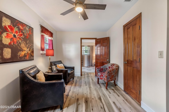 sitting room with light hardwood / wood-style floors and ceiling fan