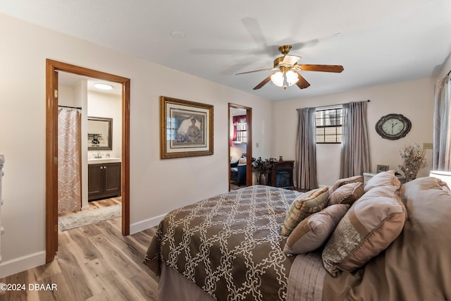 bedroom featuring ceiling fan, light wood-type flooring, sink, and ensuite bath