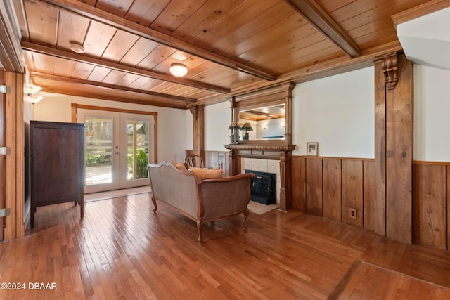 living room featuring a tile fireplace, wood-type flooring, wood ceiling, and french doors