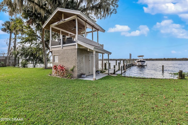 view of dock with a water view, a yard, and a balcony