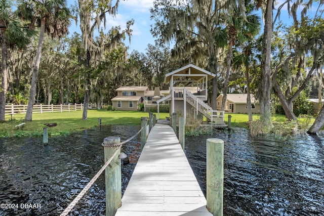 view of dock featuring a yard and a water view