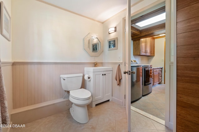 bathroom with ornamental molding, vanity, tile patterned flooring, independent washer and dryer, and toilet