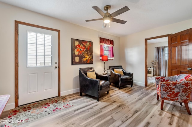 living area featuring ceiling fan and light hardwood / wood-style floors