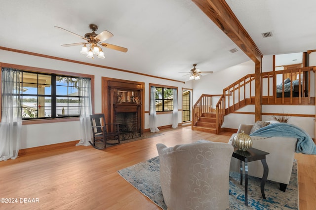 living room with plenty of natural light, beamed ceiling, and light wood-type flooring