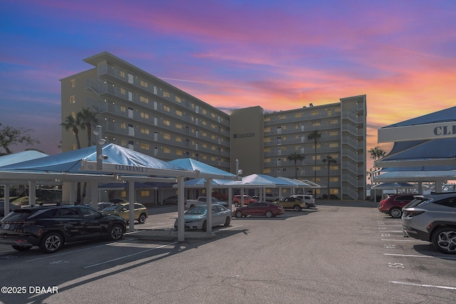 property at dusk with covered and uncovered parking