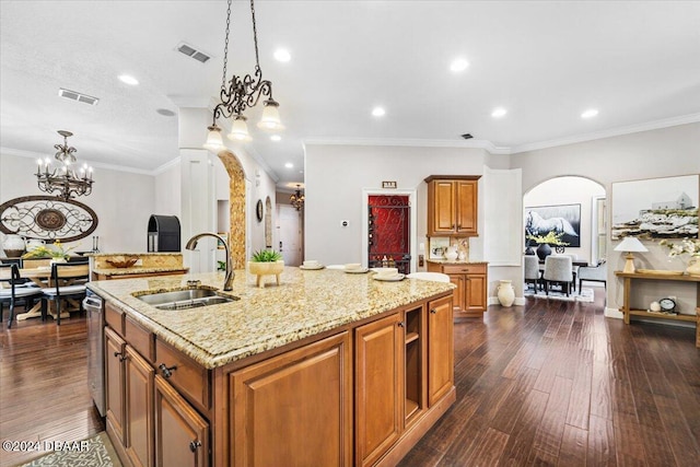 kitchen with crown molding, dark hardwood / wood-style flooring, hanging light fixtures, sink, and an island with sink