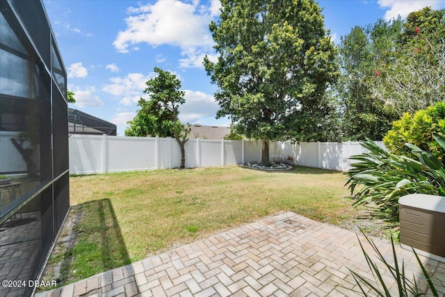 view of yard featuring glass enclosure and a patio area