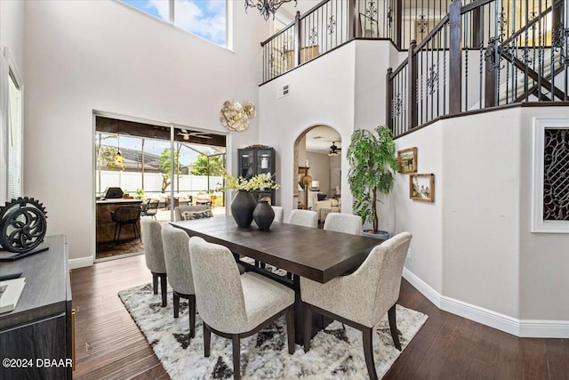 dining room with dark wood-type flooring, a high ceiling, ceiling fan, and plenty of natural light