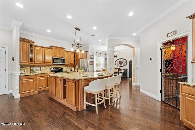 kitchen featuring stainless steel appliances, dark wood-type flooring, and a center island with sink