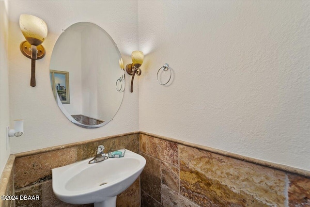 bathroom featuring tile walls and sink