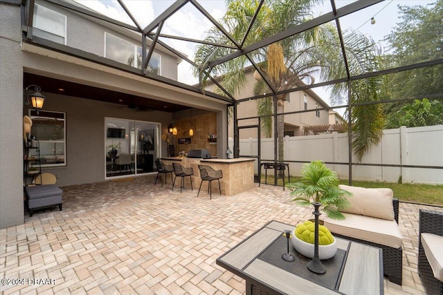 view of patio with an outdoor bar and glass enclosure