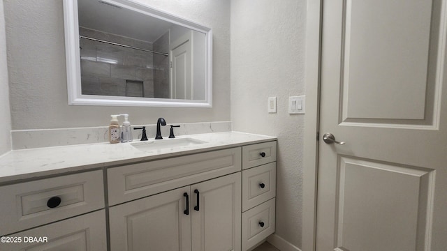 779 Aspen Dr, South Daytona, FL 32119 - bathroom featuring a textured wall, vanity, and a shower