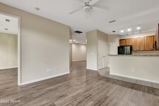 253 Catriona Dr, Daytona Beach, FL 32124 - unfurnished living room with light wood-style floors, visible vents, baseboards, and a ceiling fan