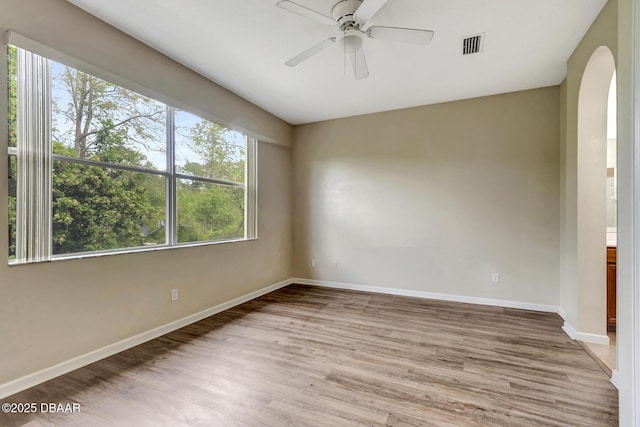 253 Catriona Dr, Daytona Beach, FL 32124 - empty room featuring baseboards, light wood-style floors, visible vents, ceiling fan, and arched walkways