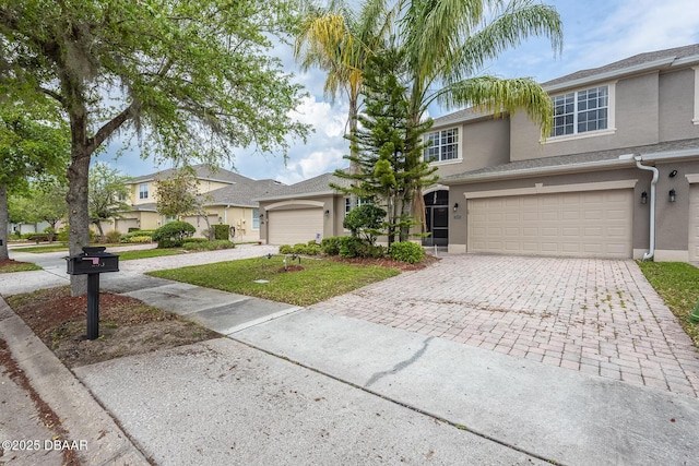 253 Catriona Dr, Daytona Beach, FL 32124 - traditional home featuring a garage, stucco siding, and decorative driveway